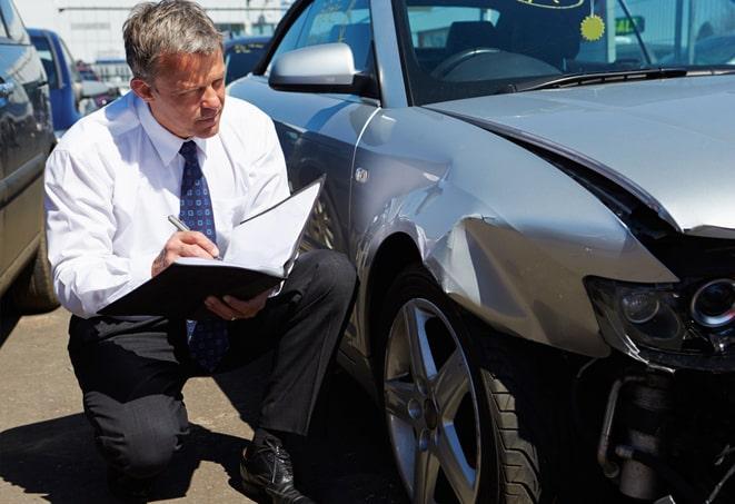 white car with insurance paperwork and keys on a desk